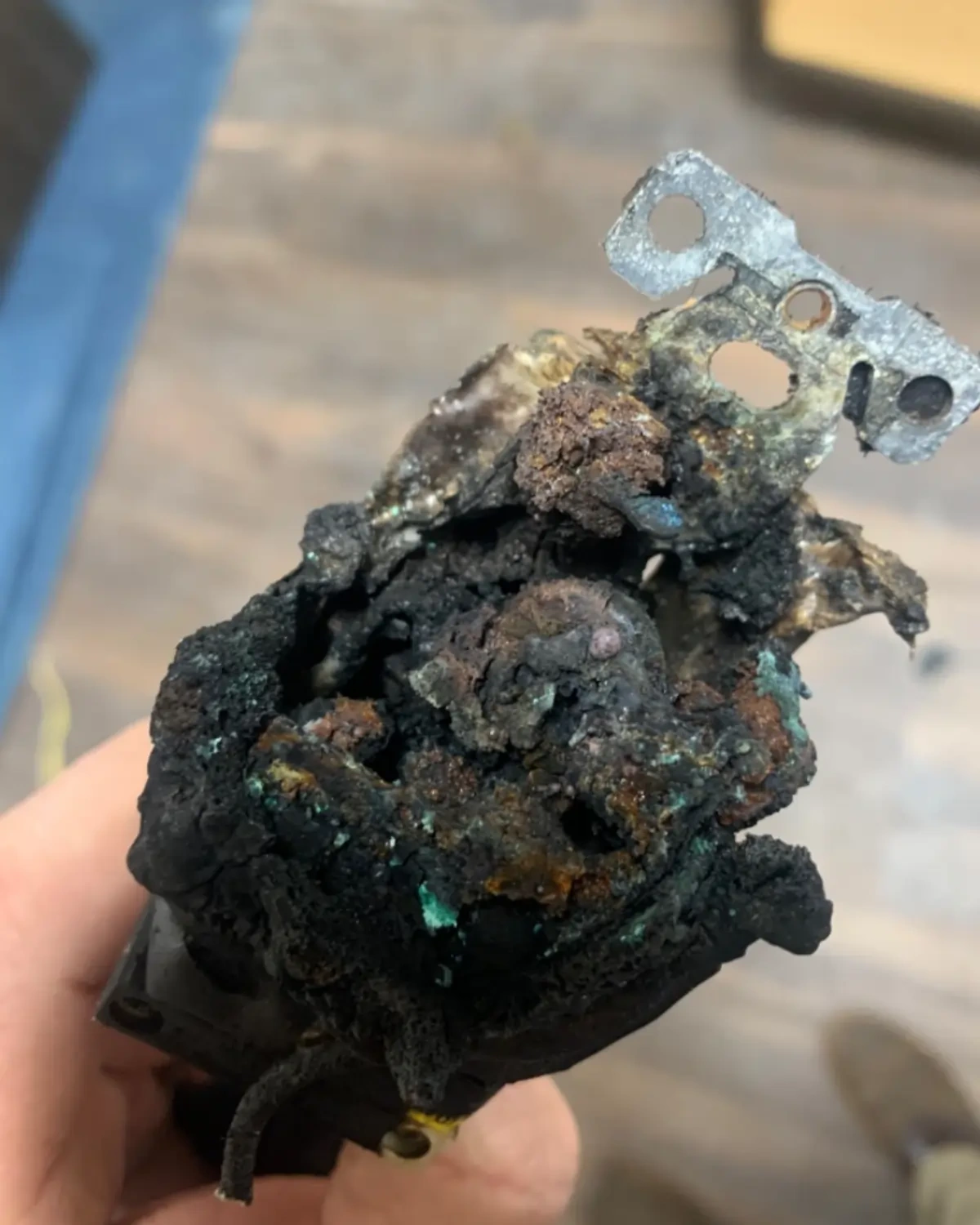 Severely burnt and corroded electrical outlet component representing the dangers of electrical faults