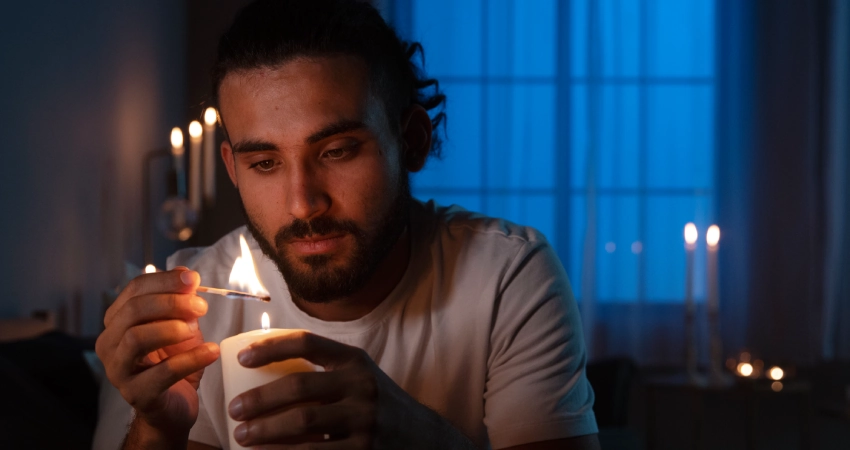 A man lighting a candle in a dark room during a Power outage in Atlanta.