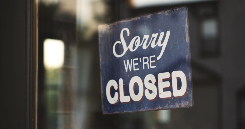 “Sorry, we’re closed” sign on a storefront window indicating a pause for electrical repairs.